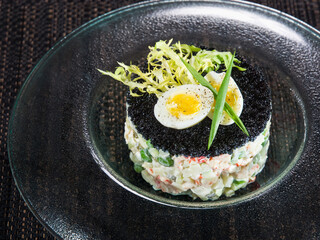 Traditional Russian vegetable salad with black caviar