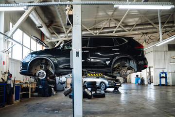 Car service, repair, maintenance concept. Car raised on car lift in autoservice.