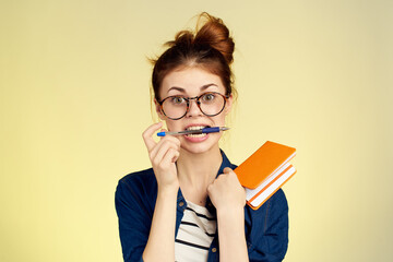 woman student with glasses notepad with pen yellow background