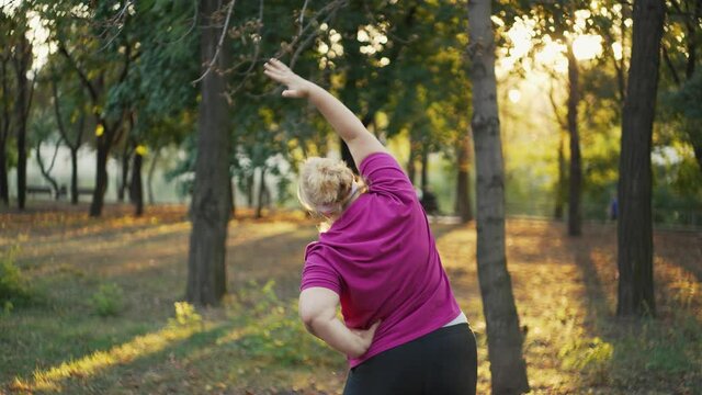 Back view of obesse woman doing exercises