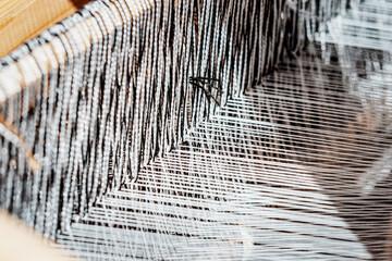 spinning cotton thread with a wooden retro craftsman spinner machine. Culture and tradition concept