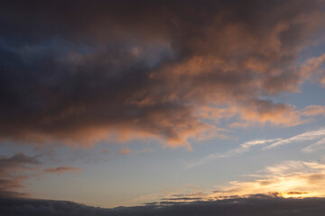 Naklejka na ściany i meble Dark dramatic sunset cloudy sky. Nature background. Warm and cool tone.
