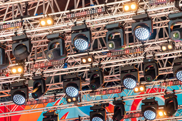 Professional spotlights and other lighting equipment on the music stage