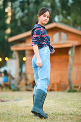 Portrait of cowgirl. Beautiful Young asian woman gardener in red plaid shirt at summer sunset.