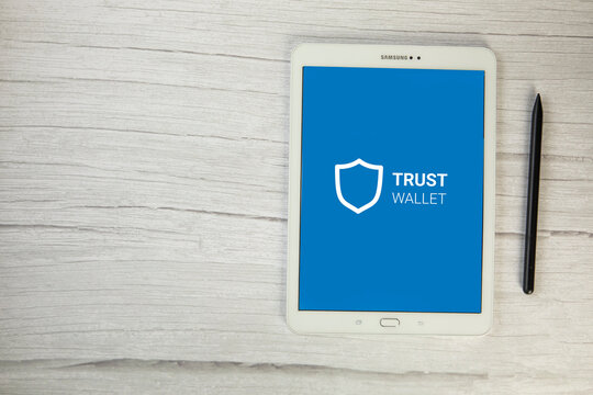 Trust wallet app Crypto Bitcoin Ewallet on digital tablet top view on wooden table, secure payment for cryptocurrency