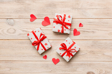 Valentine day composition Background: red gift box with bow and heart. Christmas present. View from above. Holday greeting card