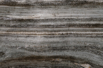 Gray marble with a decorative effect. Striped stone. Selective focus.