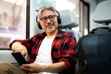Happy man traveling by train. Man listening the music while enjoying in travel.