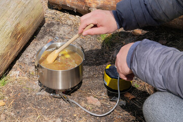 Camping food making. Tourist foods in outdoor activities. Soup in bowler in the forest for trevelers.