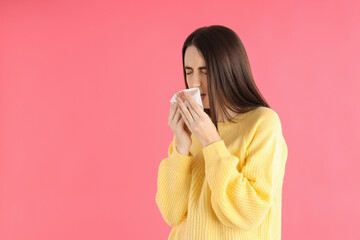 Sick girl in a yellow sweater on a pink background
