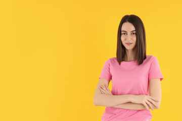 Obraz premium Young attractive woman in t-shirt on yellow background