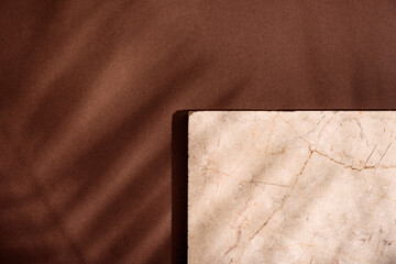 Luxury marble and brown paper color background with tropical palm shadow. Natural material with exotic plant shade branding layout. Minimal flat lay product podium with leaf silhouette overlay.