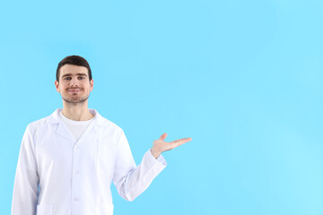 Young man doctor on blue background, healthcare and medicine