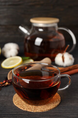 Concept of hot drink with tea on dark wooden table