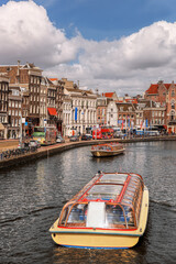 Amsterdam city with tourist boats on canal during springtime in Netherlands. - 472592809