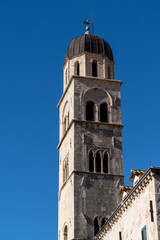 Fototapeta na wymiar the Franciscan Church bell tower in the historic city center of Dubrovnik under a blue sky