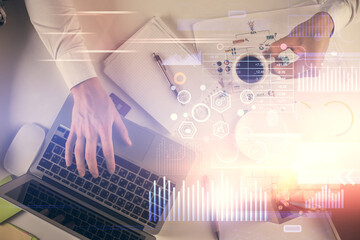 Double exposure of man's hands typing over computer keyboard and data theme hologram drawing. Top view. Technology concept.