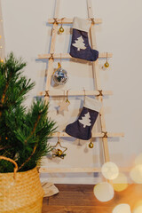 Scandinavian Christmas decoration. Fir branches in wicker basket. Wooden stair with christmas socks.