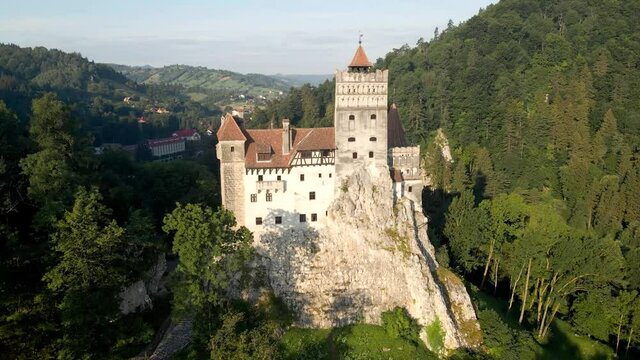 Panoramic aerial view of Bran Castle known as dracula castle in transylvania, Romania surrounded by a lush forest.