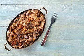 Mushroom beef stroganoff, a casserole of boletus, champignons, and meat, with cream sauce, shot from above on a rustic wooden background
