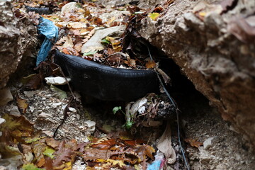 old car tyre with stones inside abandoned in a dry creek bed - italian countryside
