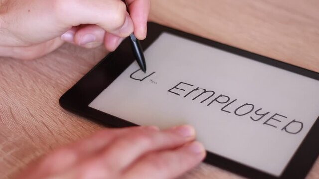 Writing UNEMPLOYED on Electronic tablet and crossing it out