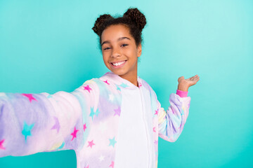 Photo of young black girl good mood shoot video show arm empty space isolated over turquoise color...