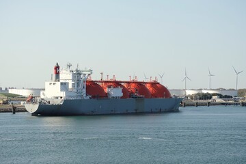Naklejka premium Port of Rotterdam, Netherlands - 07 29 2020: LNG tanker Arctic Voyager during loading operations in the port of Rotterdam