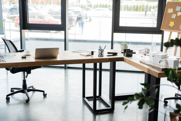 Fototapeta na wymiar Gadgets, coffee and model of building in office.