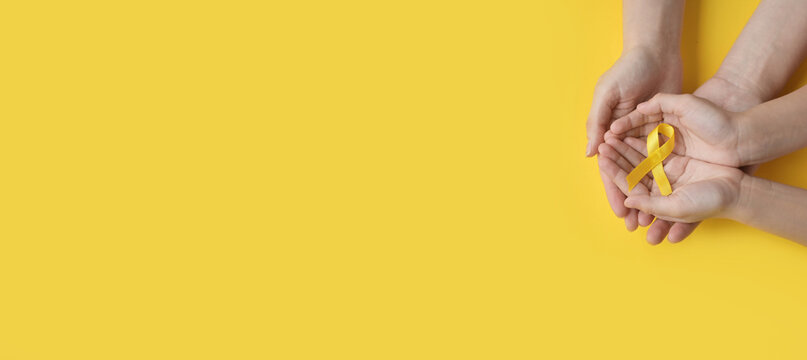 International Childhood Cancer Day. Mom and baby are holding a yellow ribbon in their hands. Sarcoma Awareness, Bone cancer, childhood cancer awareness. Concept I Am and I Will. banner. copy space
