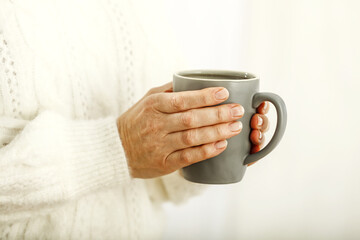 Woman hands and mug with hot drink 
