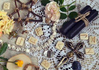 Still life with pentagram, black candles and runes with magic objects on witch table.