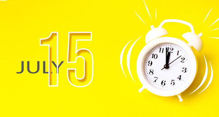 July 15th. Day 15 of month, Calendar date. White alarm clock with calendar day on yellow...