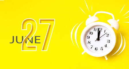 June 27th. Day 27 of month, Calendar date. White alarm clock with calendar day on yellow...