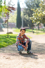 Naklejka na ściany i meble Smiling boy wearing casual clothes while posing at city park