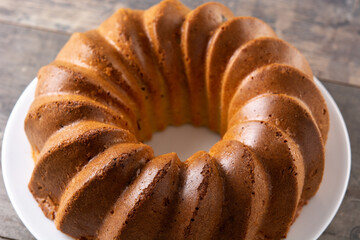 Traditional bundt cake piece with raisins on wooden table	