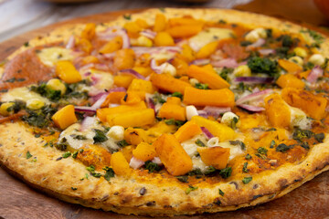 tarte au potiron avec légumes et épices sur un fond de bois	