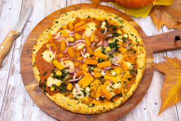 tarte au potiron avec légumes et épices sur un fond de bois	