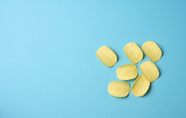 round potato chips on a blue background, top view