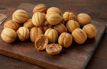 baked dessert nuts with condensed milk on a wooden board, top view