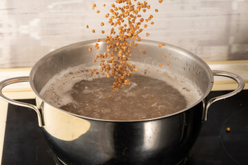 pour buckwheat into a metal pan with boiling water