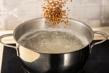 pour buckwheat into a metal pan with boiling water