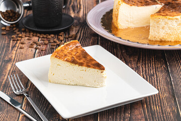 Sliced san sebastian cheesecake with coffee on wooden table