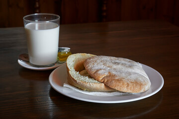 freshly baked bread muffin for breakfast with a glass of milk and olive oil, typical of andalusia. Spain