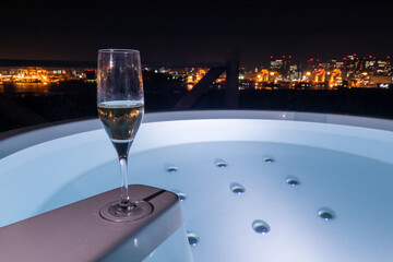 夜の都会の街並みを望む露天風呂とシャンパングラス outdoor bath and a champagne glass	