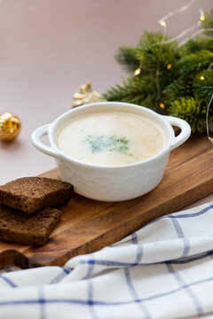 Winter salmon soup in a white plate on a board with a piece of Borodino bread. Food photos