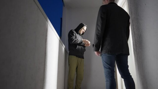 Two men doing a drugs deal or criminal transaction