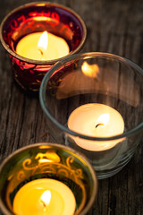 burning candles in jars on table