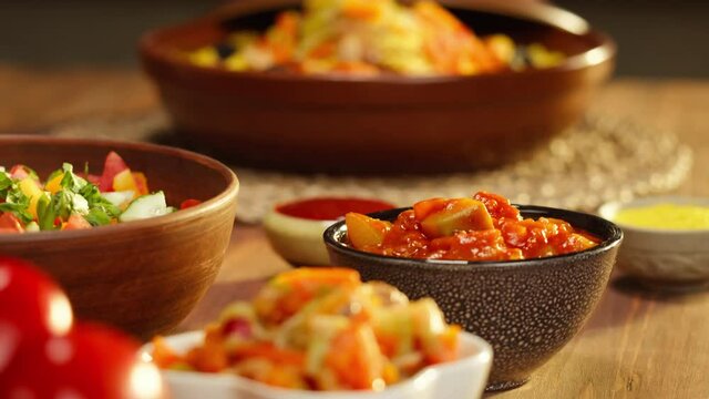 Moroccan cuisine. Tajine, traditional dish made of lamb and eggplant, vegetable salad. Middle eastern culture. Couscous with mutton close-up, delicious rice. Homemade food. 
