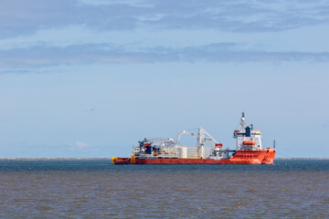 Ship on the ocean horizon. Profile of industrial supply vessel.